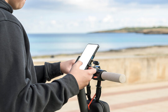 E-Mobility young man with electric scooter using smartphone app