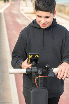 Front view 14-17 years old smiling happily riding electric scooter