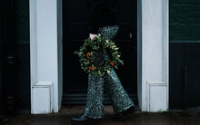 Woman Holding Christmas Wreath With Sparkly Trousers On
