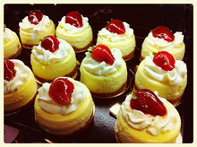 A Close-up Of Mini Strawberry Shortcake Pastries On Display In A Pastry Shop.