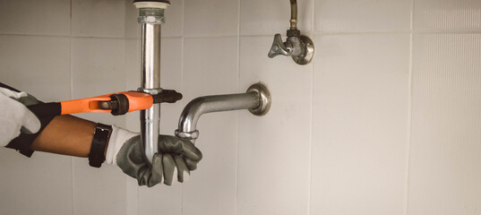 plumber at work in a bathroom, plumbing repair service , fix water plumbing leaks, replace the kitchen sink drain