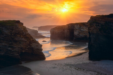 Wall Mural - Cathedrals beach (Playa de las Catedrales) or Praia de Augas Santas at sunrise, amazing landscape with rocks on the Atlantic coast and colored sky, Ribadeo, Galicia, Spain. Outdoor travel background