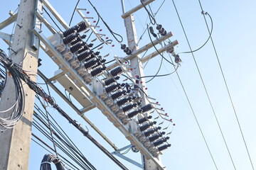 Wall Mural - Capacitor bank on pole. close up capacitor bank for increasing control efficiency and reducing voltage loss in high voltage transmission lines on blue sky background with copy space. selective focus