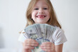 © H_Ko - Portrait of happy smiling little girl with fan of dollars