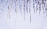 Fototapeta Na ścianę - Sople lodu zwisające z dachu zimą.