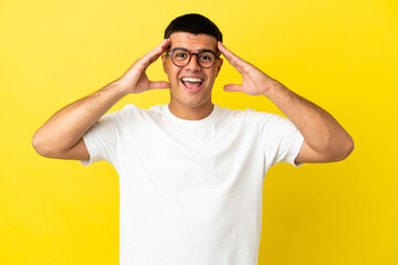 Wall Mural - Young handsome man over isolated yellow background with surprise expression