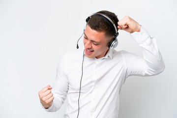 Wall Mural - Telemarketer Brazilian man working with a headset isolated on white background celebrating a victory