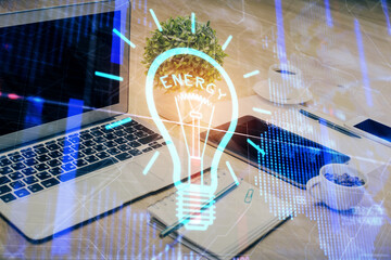 Poster - Computer on desktop in office with bulb icon hologram. Double exposure. Concept of idea.