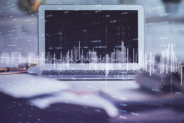 Forex market graph hologram and personal computer on background. Double exposure. Concept of investment.