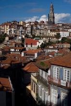 Red Roofs Cover An Urban Hill Side With Large Clock Tower On Top Of The Hill And Blue Sky.
