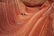 © Cavan Images - A desert hiker relaxes in the surreal landscape of a sandstone slot canyon