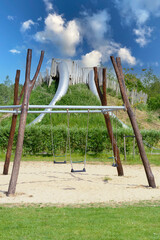 Children's playground with the swing in the park in the summer. One summer day on the empty playground