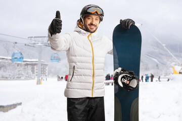 Sticker - Guy with a snowboard in a ski resort and gesturing thumbs up