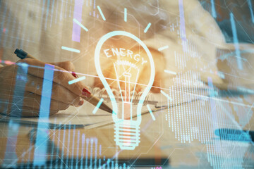Poster - Bulb hologram over hands taking notes background. Concept of idea. Double exposure