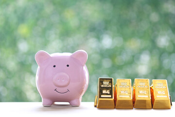 Piggy bank and gold bar on natural green background,Business investment and Saving money for prepare in future concept