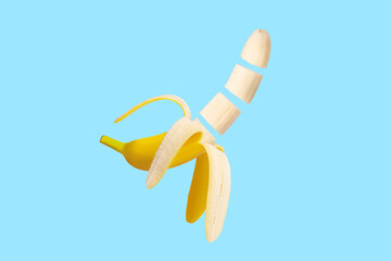 Wall Mural - Fresh raw yellow banana peeled, opened, cut in flight. isolated. On a blue background.