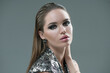 © Subbotina Anna - Beauty fashion brunette girl face make-up. Portrait with earrings, fashion hairstyle. Smokey eyes. Glamour Sexy woman with perfect trendy makeup, face contouring. Beauty trends. On grey background