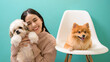 © tonefotografia - Portrait of Young beautiful woman kisses and hugs her dog over green background.