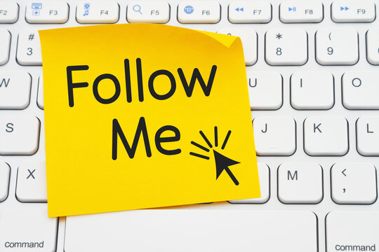 Follow me message on a yellow sticky note on a gray computer keyboard