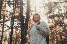 Head Shot Portrait Close Up Of Middle Age Caucasian Woman Walking And Enjoying Nature In The Middle Of Trees In Forest. Old Mature Female Wearing Glasses Trekking And Discovering.
