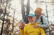 © Daniel - Head shot portrait close up of couple of cute seniors using phone together in the forest with trees around them. Using cellphone mobile outdoors having fun and enjoying.
