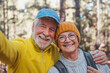 © Daniel - Head shot portrait close up of cute couple of old seniors taking a selfie together in the mountain forest looking at the camera smiling having fun enjoying. Two mature people hiking.