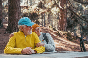 Sticker - Head shot portrait close up of cute couple of old middle age people having fun and enjoying together in the forest of the mountain at the table relaxing and resting..Mature woman hugging husband 