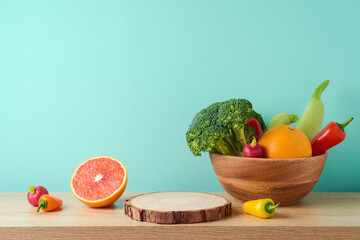 Wall Mural - Empty wooden log with vegetables and fruits on table over blue wall  background. Vegetarian kitchen interior mock up for design and product display