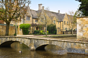 Idyllic Cotswolds village of Bourton on the Water with bridge and stone houses along the River Windrush, England