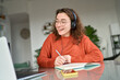 © insta_photos - Happy female student wearing headphones elearning online on computer at home. Young smiling woman using laptop remote working, talking having web conference meeting, virtual class, web seminar.