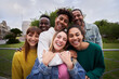 © CarlosBarquero - Young people embrace posing for a group portrait looking at the camera outside. Smiling friends of the millennial generation. Young guys and girls having fun together