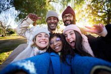 Winter Time Smiling Selfie Of A Happy Group Of Multicultural Friends Looking At The Camera. Portrait Of Cheerful Multi-ethnic Young People Of Diverse Races Having Fun Together. Colleague Hanging Out.