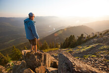 A Hiker Looks Down Towards The Skagit Valley And River From The Summit Of Sauk Mountain.