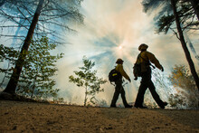 Fire Fighters Walking Along The Edge Of A Controlled Burn