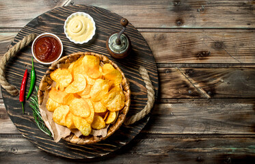 Canvas Print - Potato chips in a basket with different sauces.