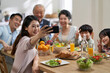 © imtmphoto - multi generational asian family taking a selfie at dining table