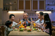 © imtmphoto - three generation asian family toasting while having dinner together
