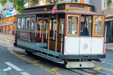 Fototapeta Londyn - Cable car in historic districts in san francisco california deep in heart of city with white color and wooden accents