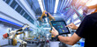 Smart industry control concept.Engineer Hands holding tablet on blurred robot arm automation machine as background