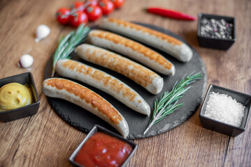 Wall Mural - grilled sausages with spices on a rustic background