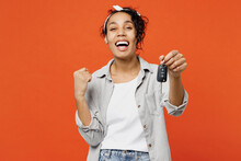 Young Fun Woman Of African American Ethnicity She Wears Grey Shirt Headband Hold In Hand Car Keys Fob Keyless System Show Thumb Up Isolated On Plain Orange Background Studio. People Lifestyle Concept.