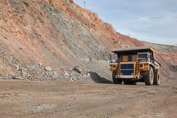 Wall Mural - Large dump truck for removal of rock mass from the quarry for open-pit mining of minerals. Initial stage of melalurgy, machinery for the extraction of raw ore.