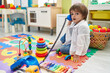 © Krakenimages.com - Adorable toddler playing with telephone toy sitting on floor at kindergarten
