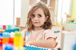 © Krakenimages.com - Adorable hispanic girl playing with construction blocks sitting on table at kindergarten
