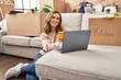 © Krakenimages.com - Young woman drinking coffee using laptop at new home