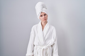 Poster - Blonde caucasian woman wearing bathrobe looking sleepy and tired, exhausted for fatigue and hangover, lazy eyes in the morning.