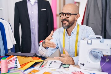 Poster - Young bald man tailor smiling confident speaking at tailor shop