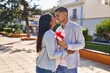 © Krakenimages.com - Young latin couple expecting baby surprise with gift at park