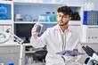 © Krakenimages.com - Young hispanic man scientist weighing sample reading document at laboratory