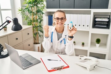 Canvas Print - Young doctor woman wearing uniform and stethoscope screaming proud, celebrating victory and success very excited with raised arms